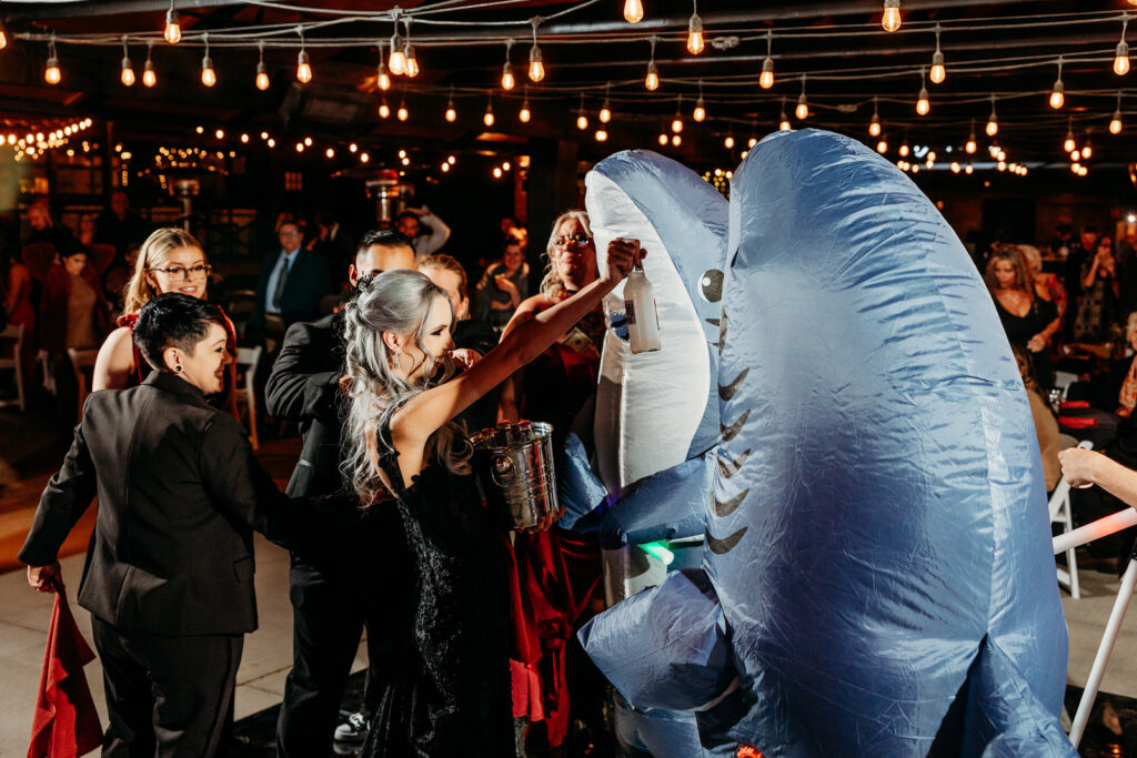 lgbtqia gothic wedding in phoenix arizona at the venue at chileens in black wedding dress at receoption with blow up sharks