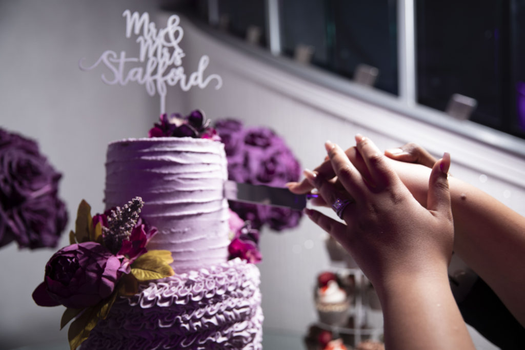 cutting the cake, which is purple