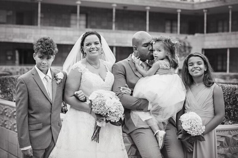 cute candid of plus size bride with groom giving daughter a peck on the cheek