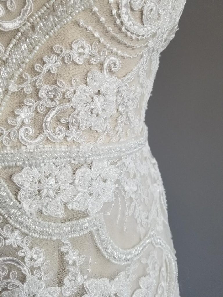 close up of plus size wedding dress beaded and lace sheath