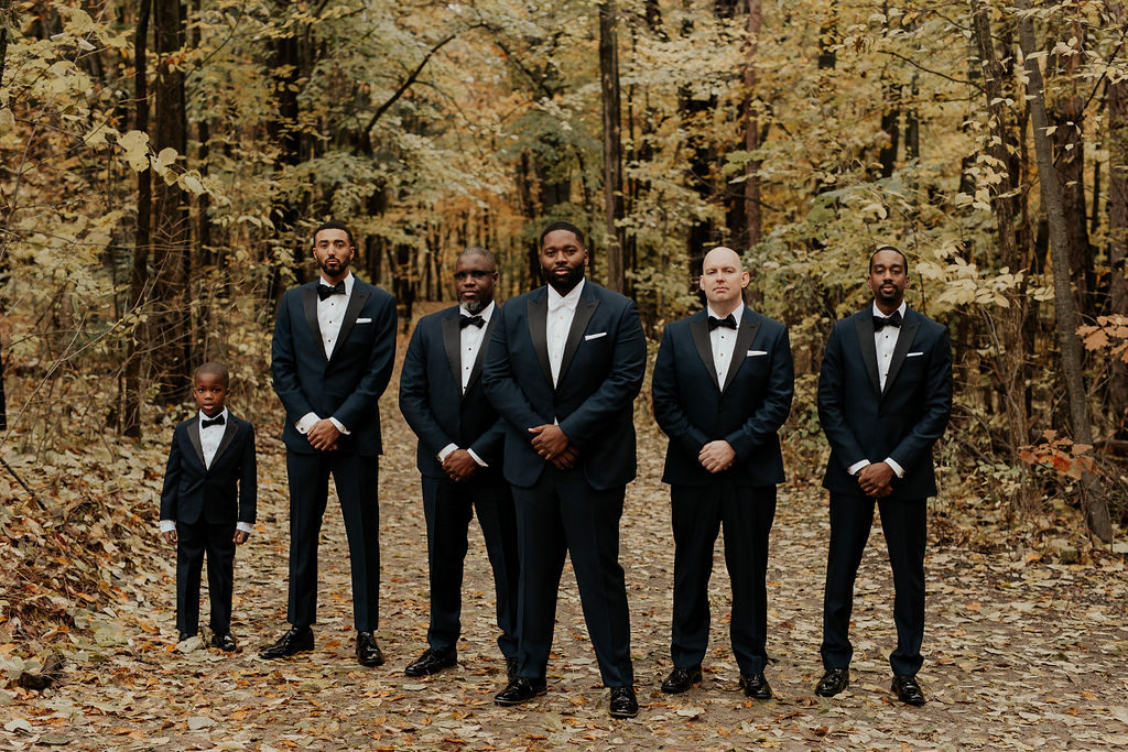 groomsmen standing in the woods