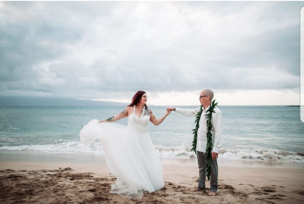 newlyweds twirling on the beach