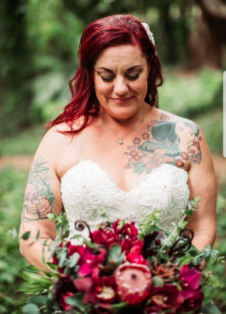 close up of plus size bride in gown holding flowers