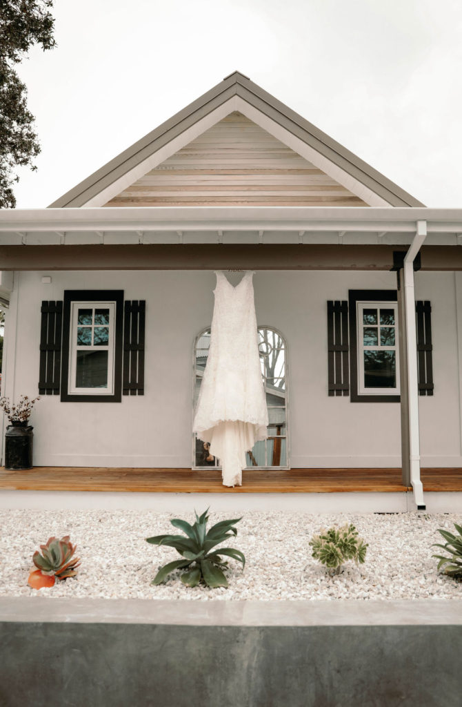 plus size wedding dress hanging outside a house
