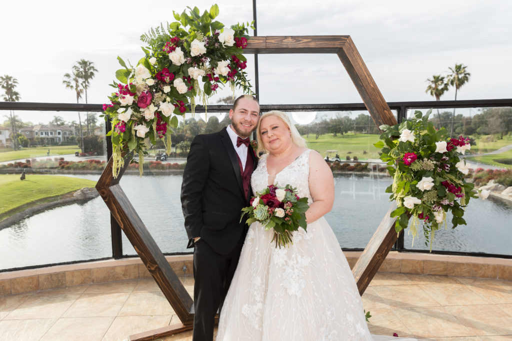 geometric wood wedding ceremony backdrop with flowers