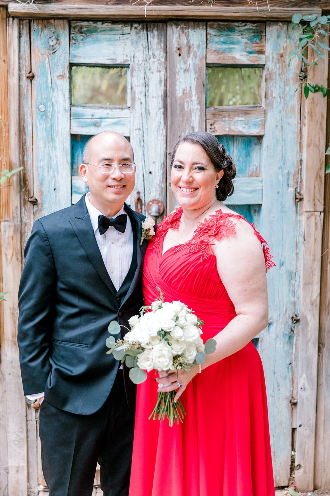 newlyweds wearing tux and custom red wedding dress