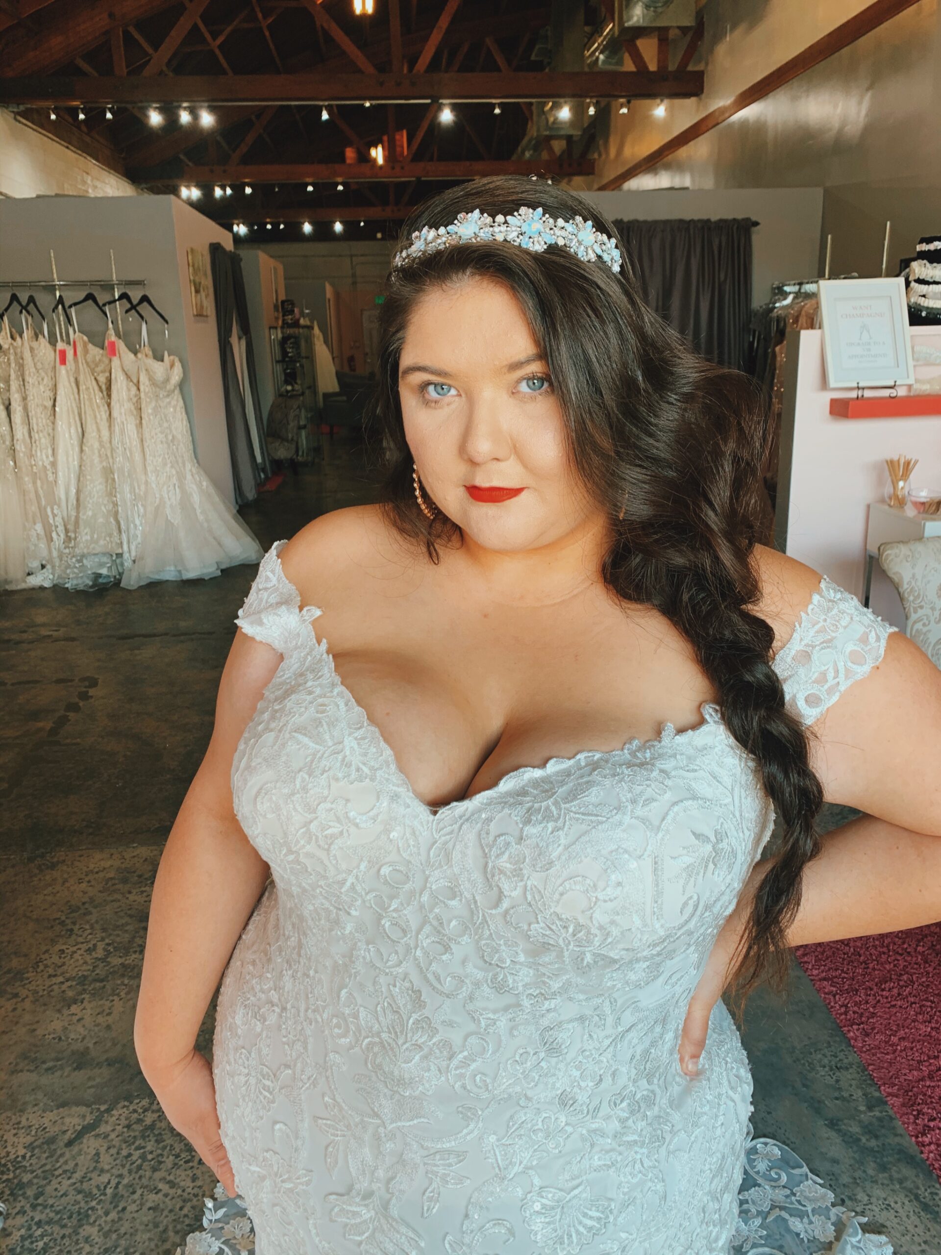 Plus size bride with red lips and blue eyes with v neck and off the shoulder with silver and opal headband