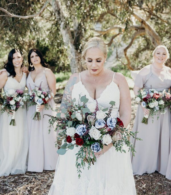 bride holding wedding bouquet with bridesmaids behind her