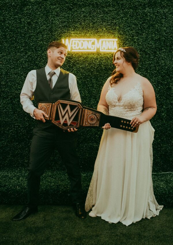 bride and groom holding a wrestling belt