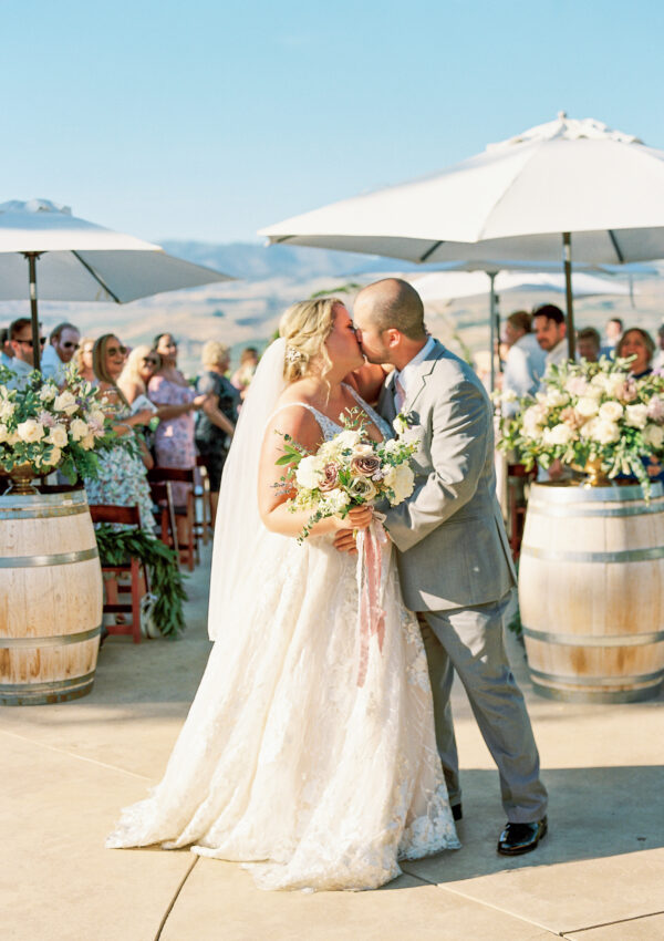 newlyweds kissing at outdoor winery wedding