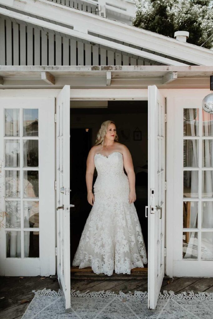 gorgeous plus size bride in lace wedding dress in open doors