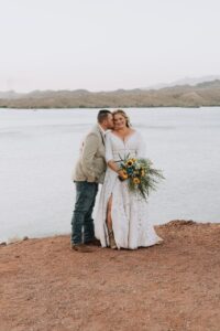 BRIDE and groom in front of lake