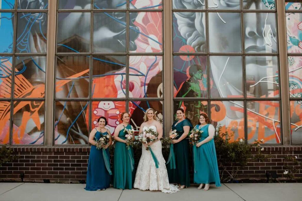 bride and bridesmaids in front of mural