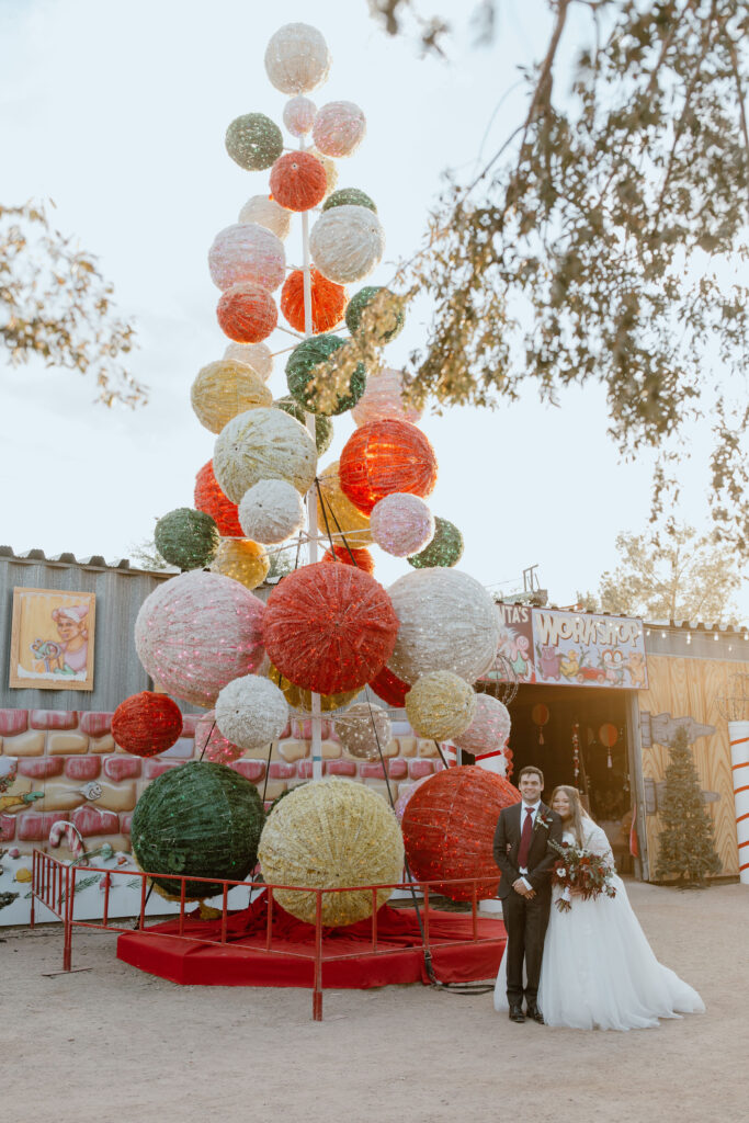 bride and groom by large christmas tree