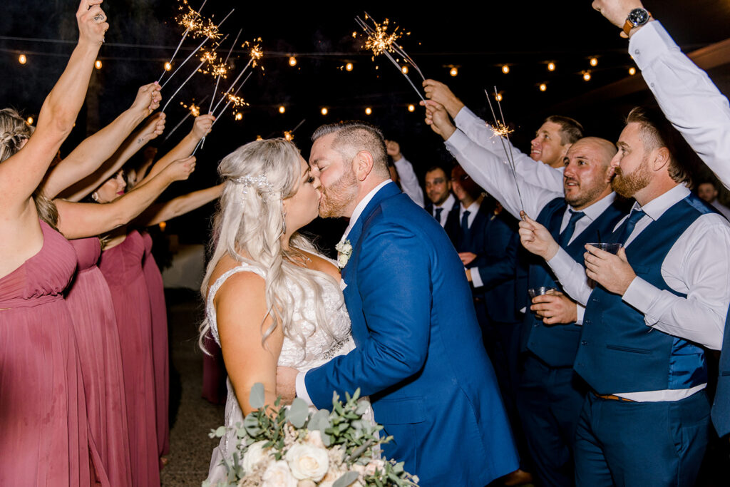 bride and groom kissing under sparklers