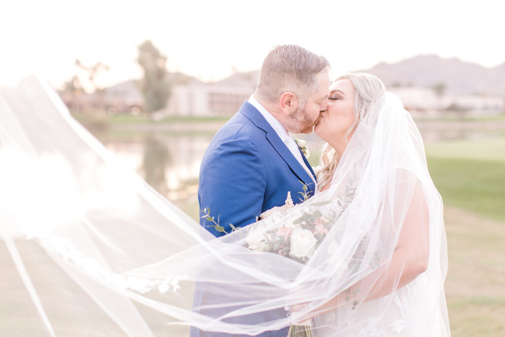 bride and groom kissing under wedding veil