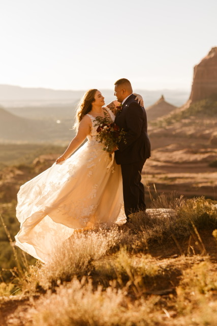 bride and groom standing on rock in sedona, arizona