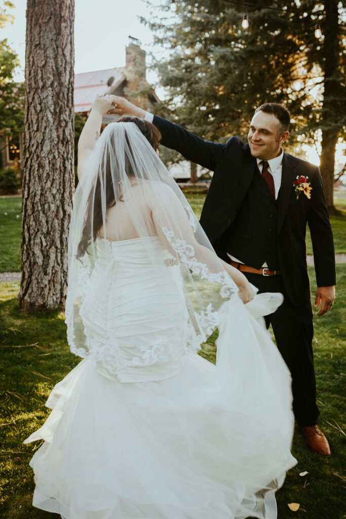 groom twirling bride wearing veil
