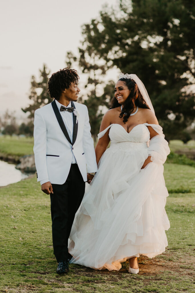 black bride and groom walking on golf course