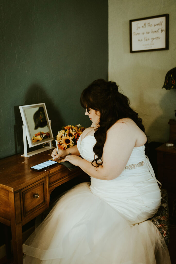 plus size bride sitting as desk writing