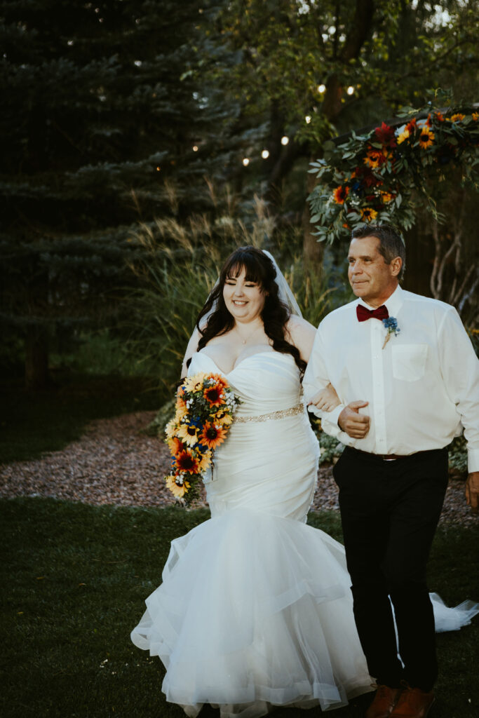 curvy bride walking down aisle with dad