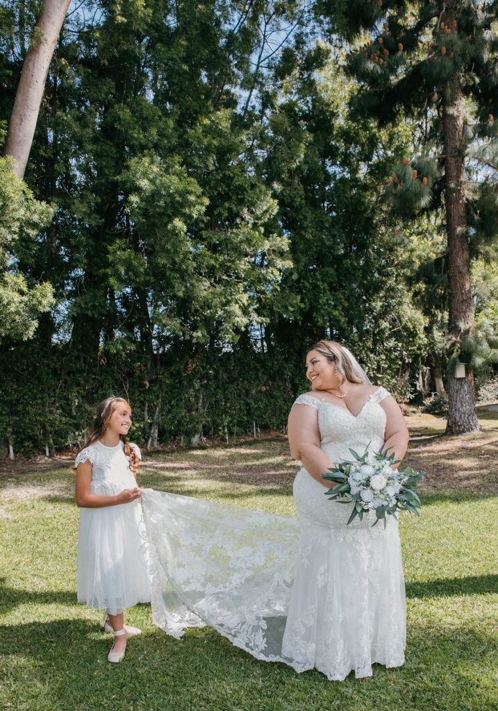 plus size bride in sheath wedding dress with flower girl