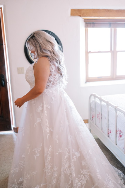 bride getting ready in plus size lace ballgown wedding dress arizona