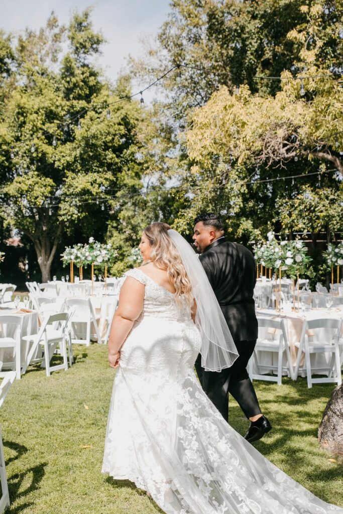 plus size bride and groom bridal walking through outdoor wedding venue