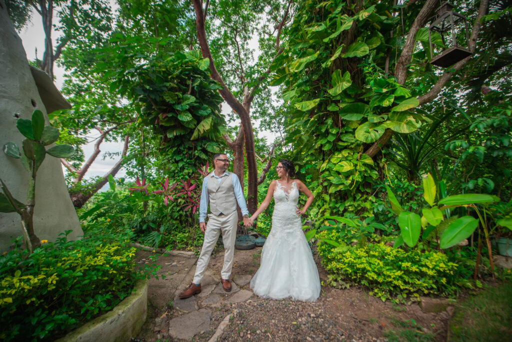 bride and groom in front of exotic greenery