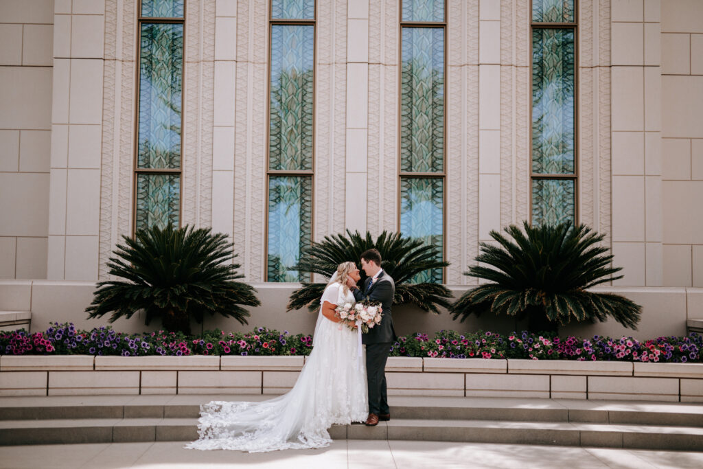 bride wearing modest wedding dress with groom in tux in front of mormon temple in mesa arizona