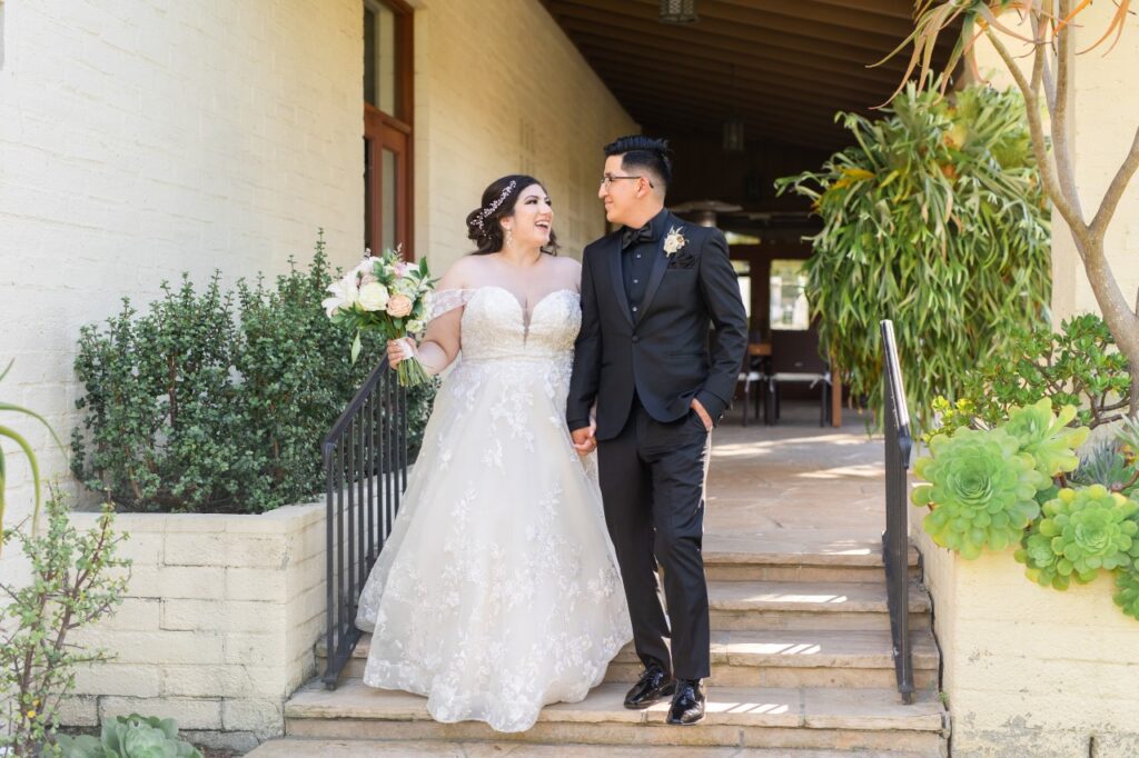 bride wearing lace ballgown with groom in black tux