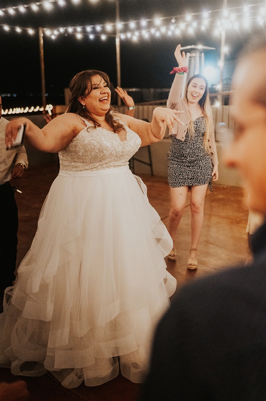 plus size bride dancing in ruffled ballgown wedding dress
