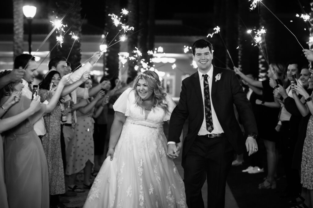 bride wearing modest wedding dress with groom in tux in front of mormon temple in mesa arizona with sparklers