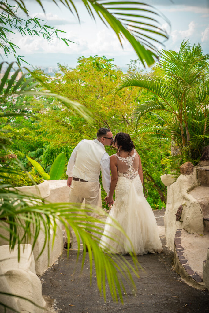 bride wearing lace mermiad dress with groom surrounded by exotic green plants