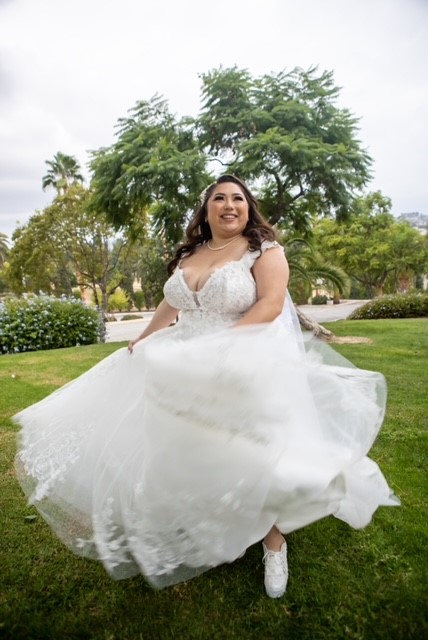plus size bride in glitter ballgown twirling on grass in long beach california