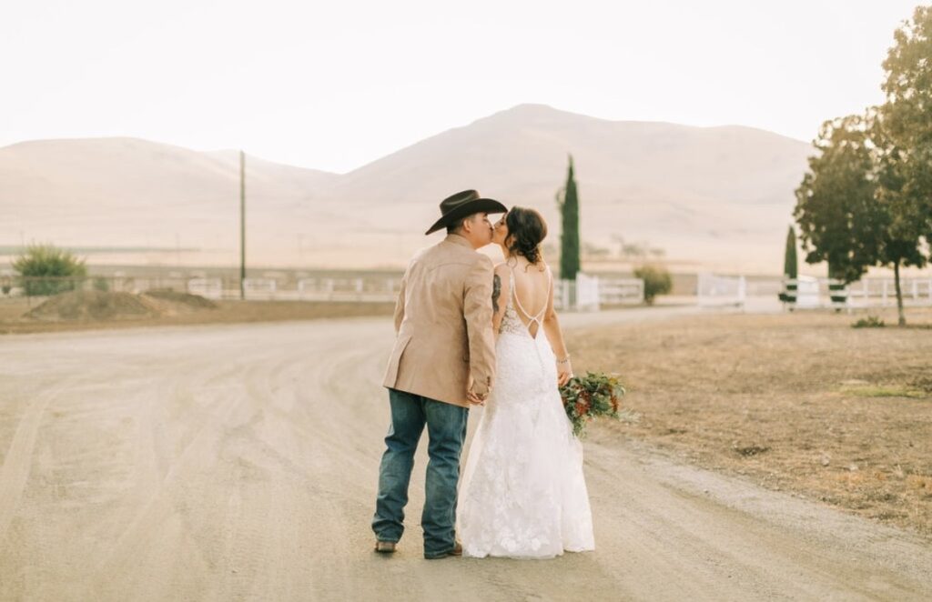 bride and groom kissing on ranch in wedding dress california