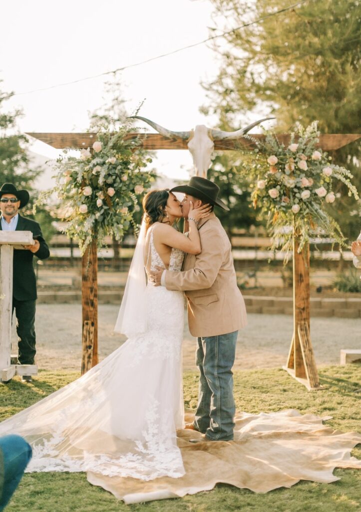 bride and groom kissing on ranch in wedding dress california