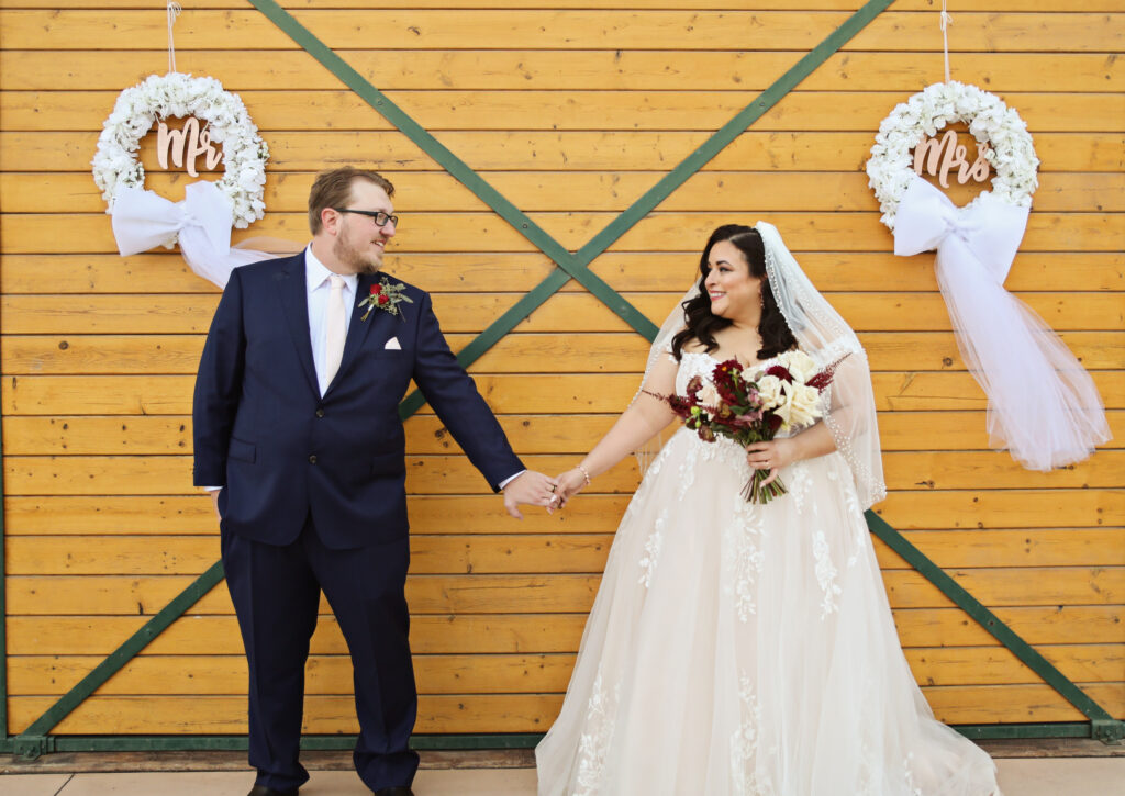 plus size bride wearing off the shoulder aline wedding dress, groom in tux los angeles california