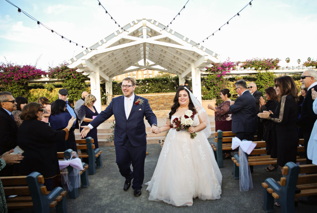 plus size bride wearing off the shoulder aline wedding dress, groom in tux los angeles california