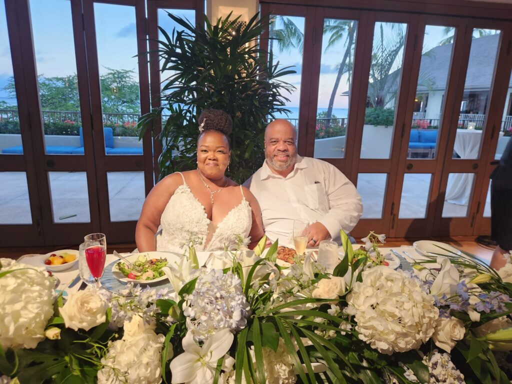 plus size bride and groom at floral sweetheart table