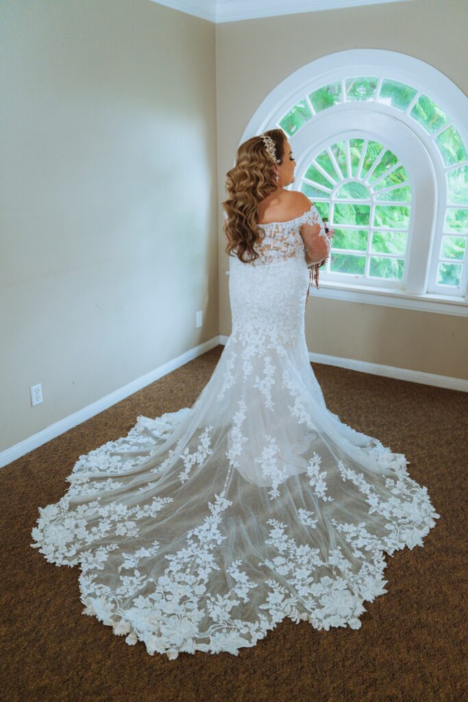 plus size bride wearing long sleeve lace fitted wedding dress with long dramatic lace train los angeles california