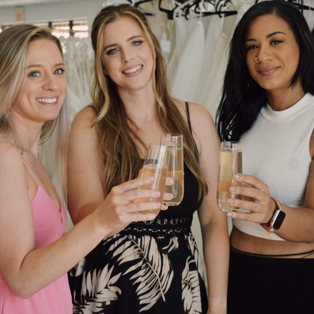 three happy brides toasting wedding dress shopping experience near me