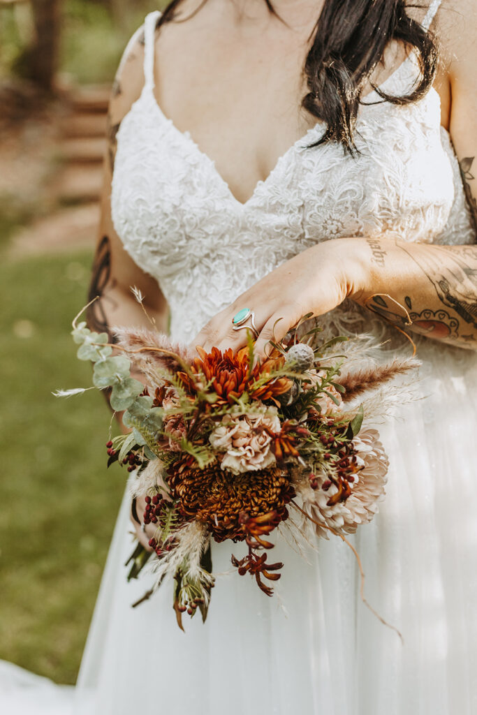 brunette woman wearing plus size wedding dress holding wedding bouquet