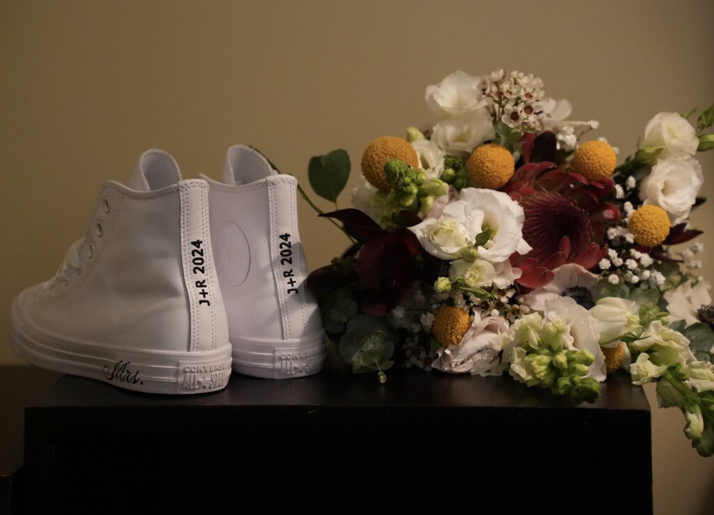 custom wedding shoes next to wedding bouquet