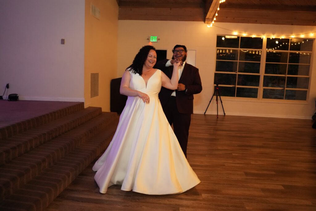 plus size bride wearing vneck mikado wedding dress groom in suit dancing in ballroom