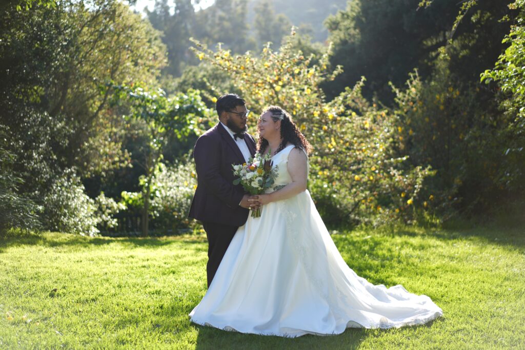 plus size bride wearing vneck mikado wedding dress groom in suit at woodsy park