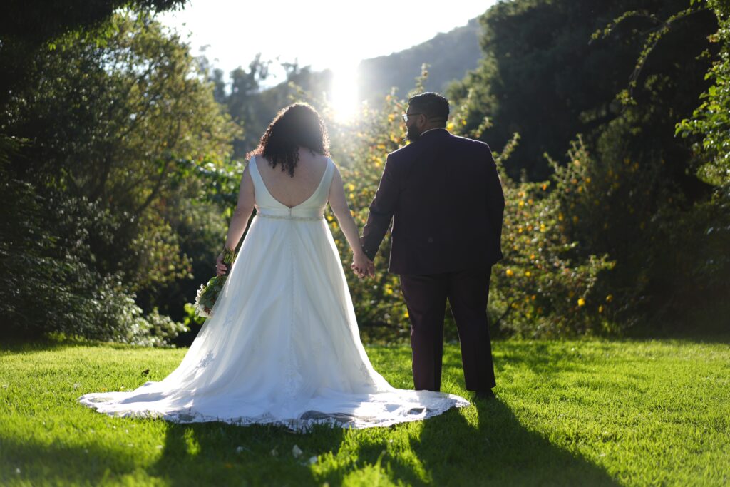 plus size bride wearing vneck mikado wedding dress groom in suit at woodsy park