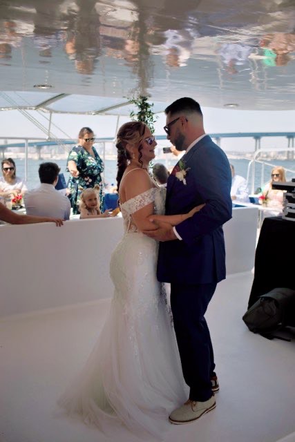 bride wearing fitted lace wedding dress on a catamaran in san diego california