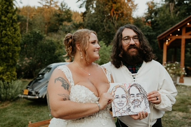 plus size bride with groom holding caricatures